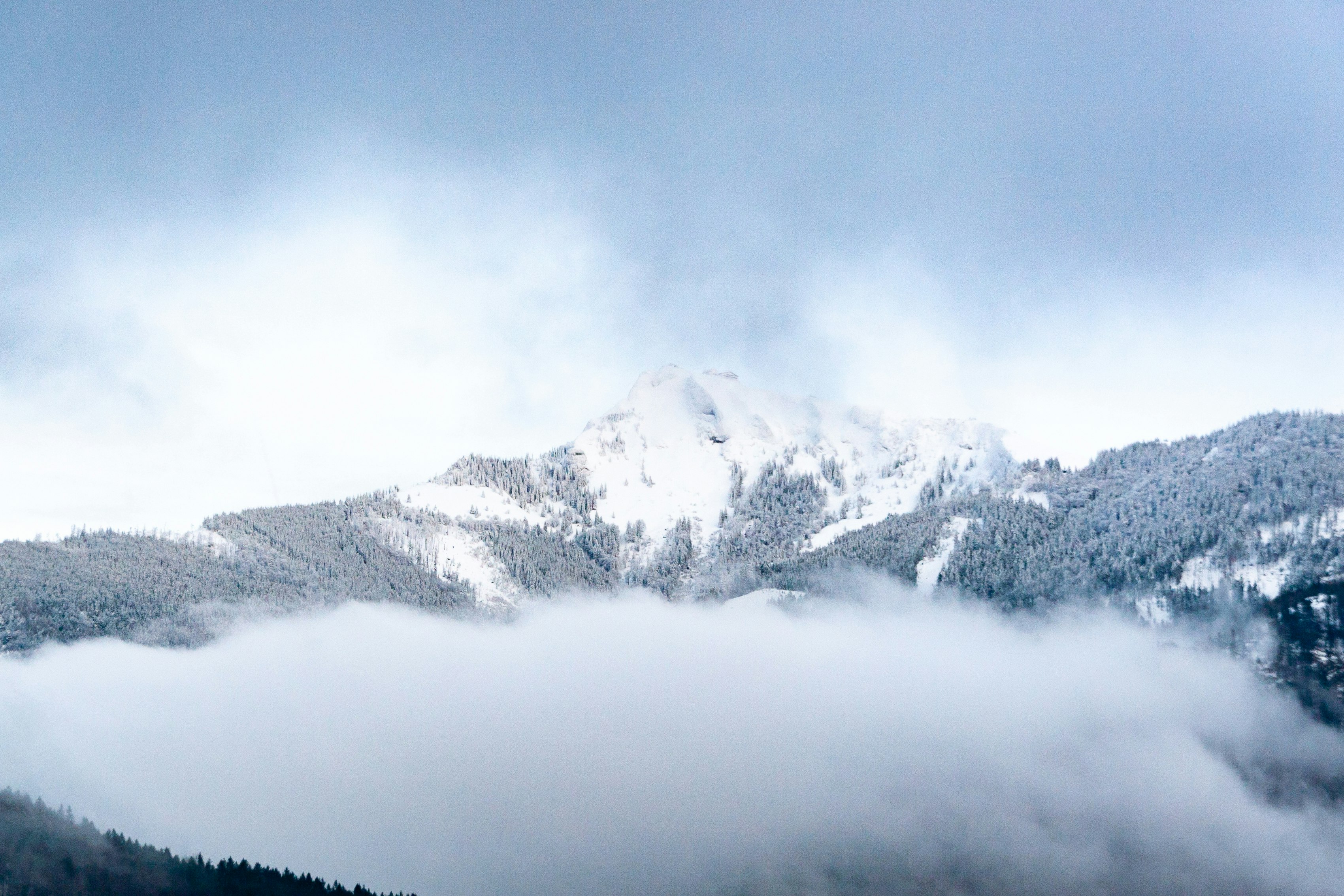 snow covered mountain under cloudy sky during daytime